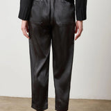Black satin straight-leg pant with fly-front closure, styled with heels