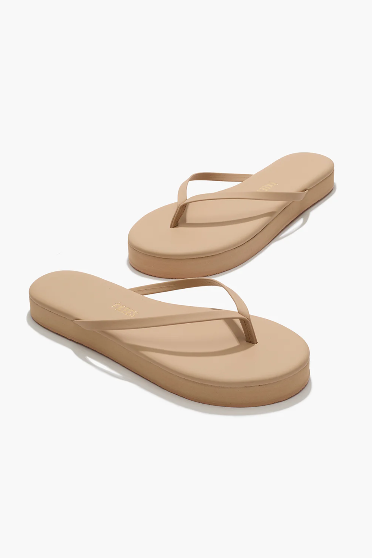Pair of beige flip-flops on a white background