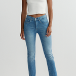 Person wearing a white sleeveless top and blue jeans on a plain background