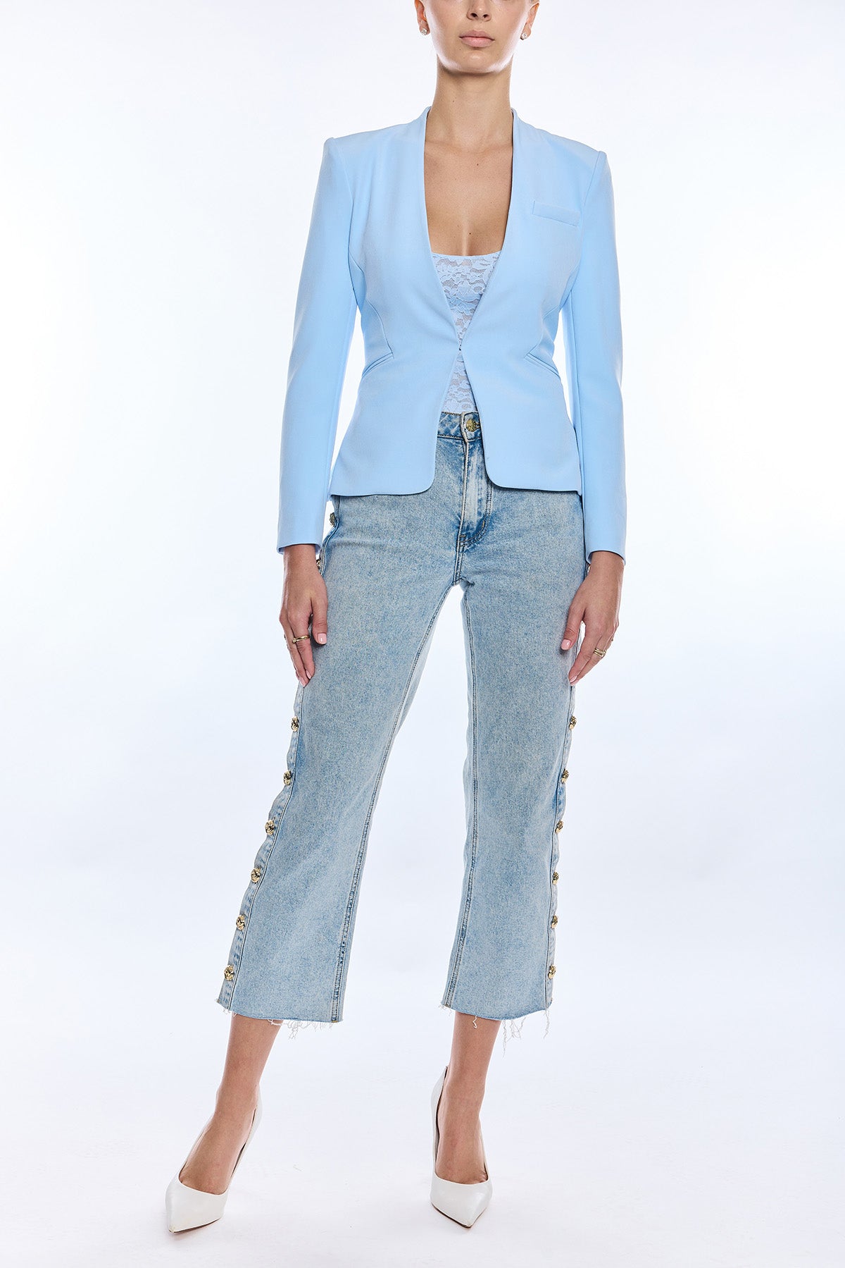 woman in light blue blazer and denim on white background