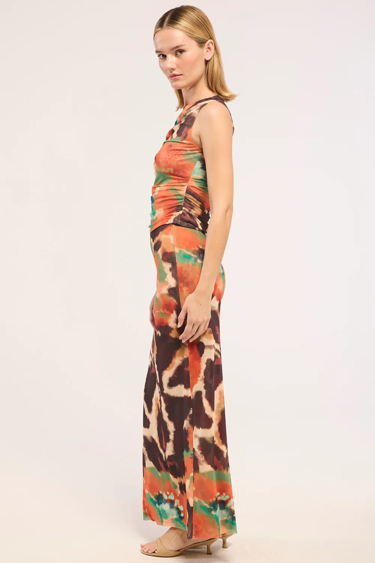 Woman wearing a colorful sleeveless top and skirt on a white background