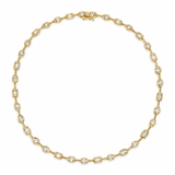 A gold tennis necklace featuring small oval-cut clear gemstones set in a yellow gold chain, displayed on a clean white background.