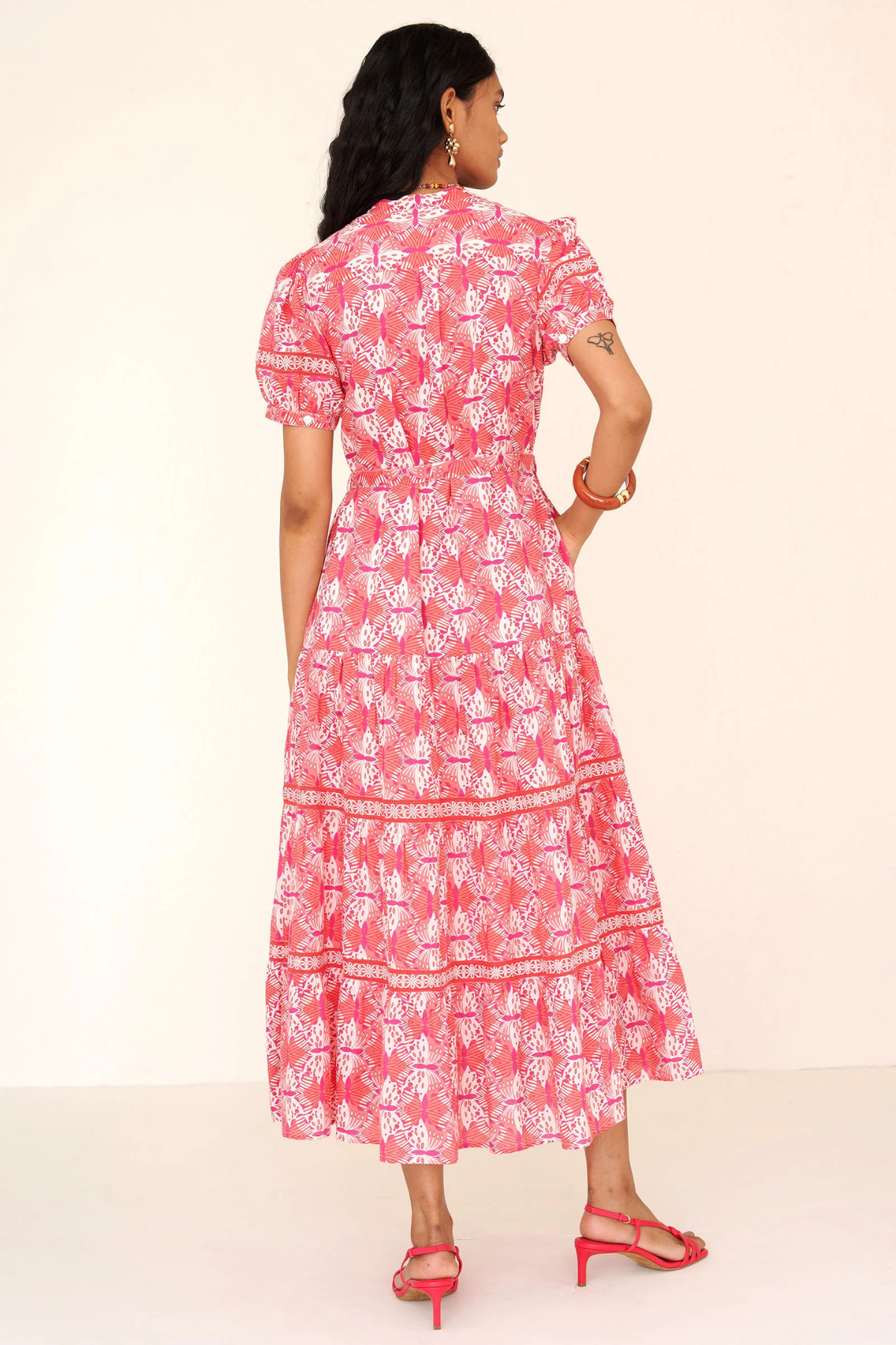 Woman wearing a pink floral dress on a white background