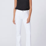 Woman wearing a black top and white pants on a plain background