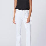 Woman wearing a black top and white pants on a plain background