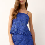 Woman wearing a blue lace dress on a white background