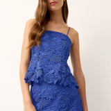 Woman wearing a blue lace dress on a white background