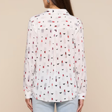 Woman wearing a white blouse with colorful pattern on a beige background