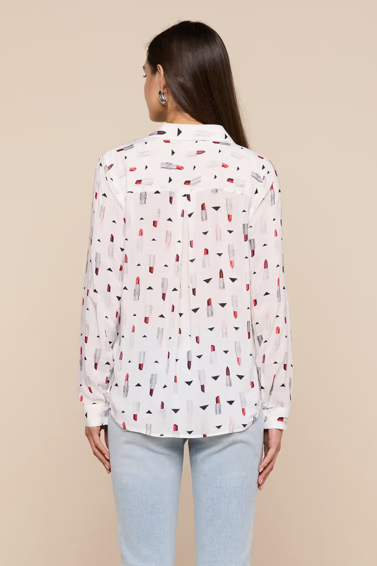 Woman wearing a white blouse with colorful pattern on a beige background