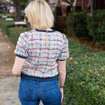 Tweed top with a structured silhouette in neutral tones.