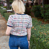 Tweed top with a structured silhouette in neutral tones.