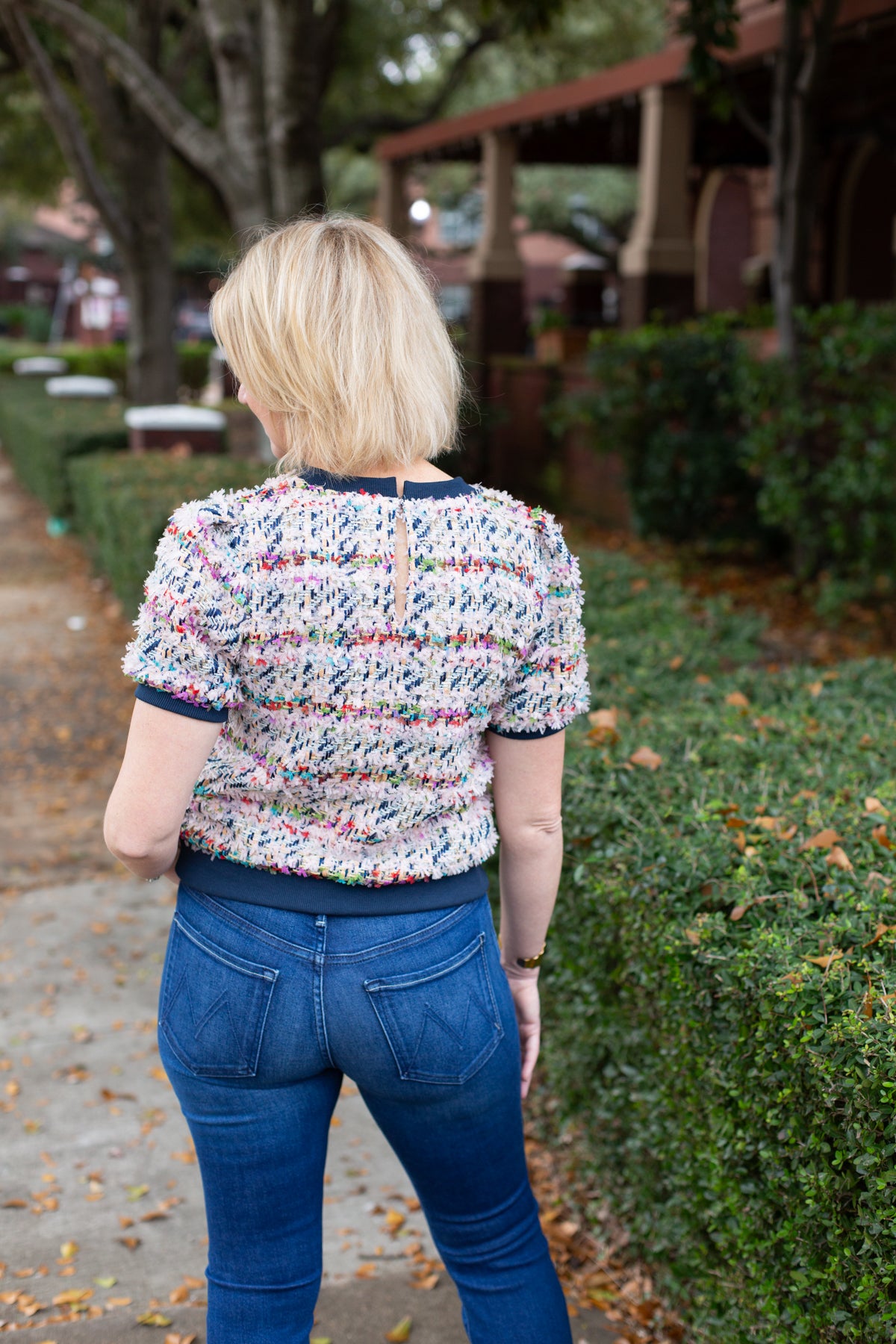 Tweed top with a structured silhouette in neutral tones.