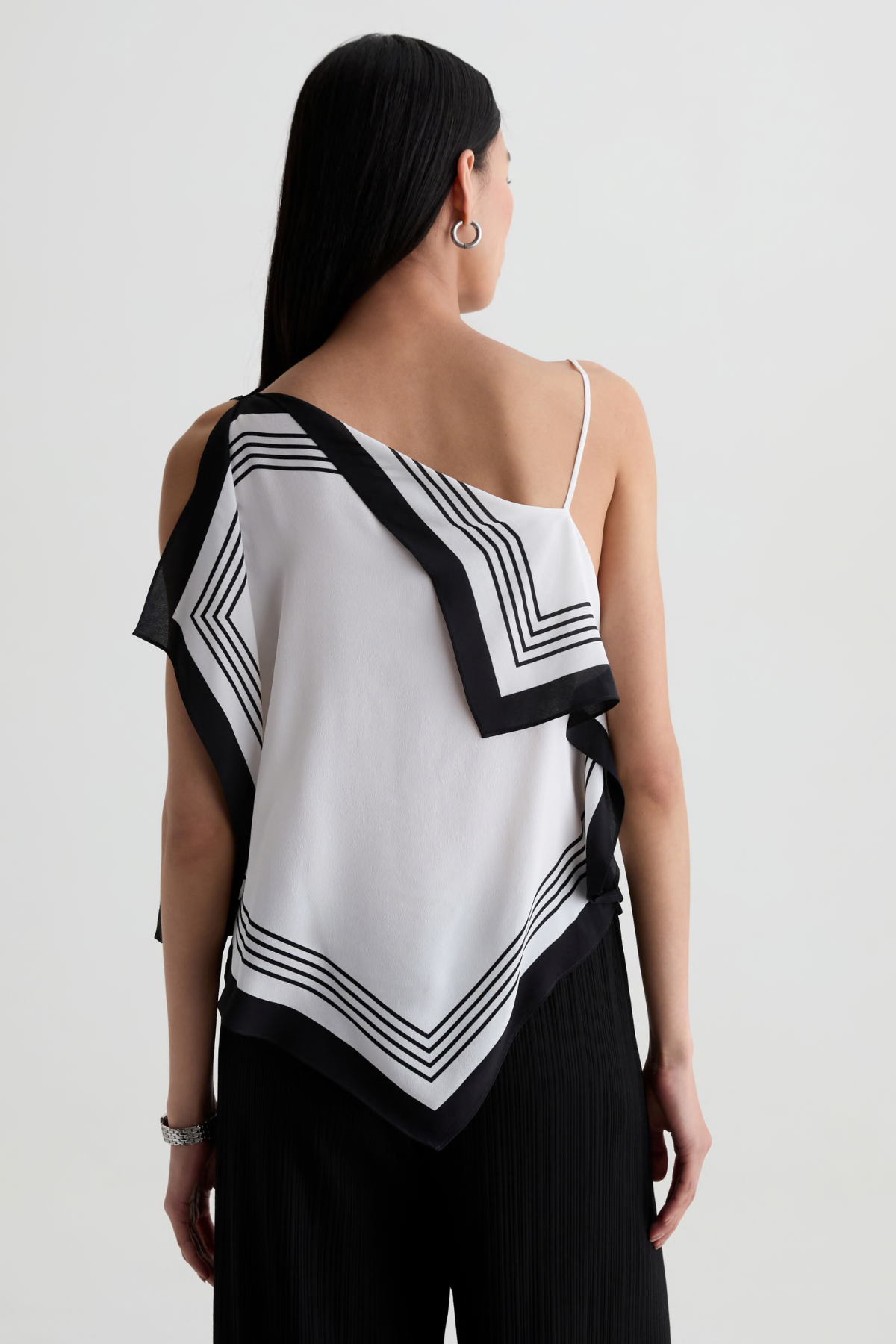 Model wearing a contemporary sleeveless printed top with a relaxed, flattering silhouette.