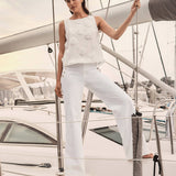 Woman in a white outfit standing on a yacht