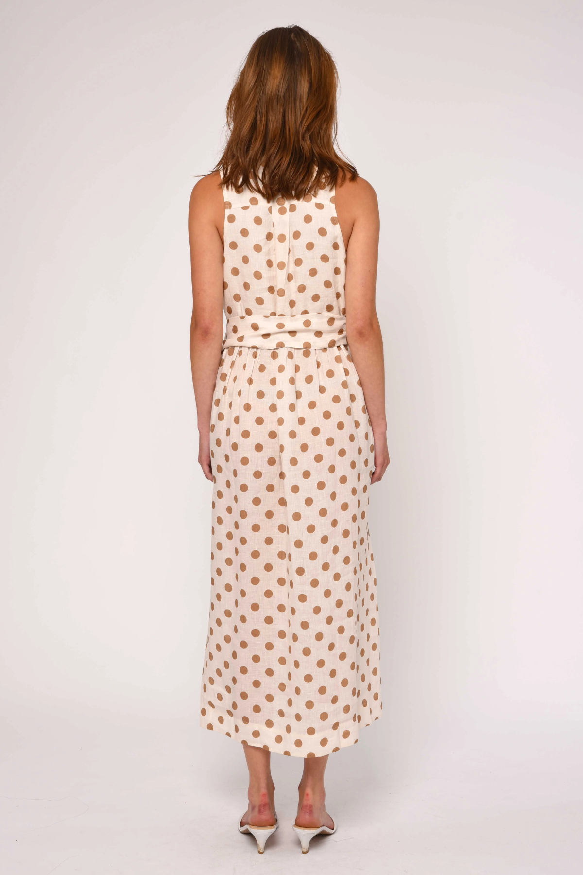 Woman wearing a polka dot dress on a white background