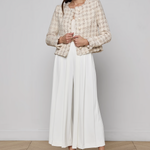 Collarless tailored jacket in a neutral tone, styled over a lightweight top