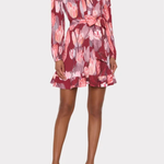 A model wearing a long-sleeve wrap-style mini dress with a pink, red, and gray floral pattern, featuring a tie waist and ruffled hem, paired with clear high-heeled sandals against a light gray background.