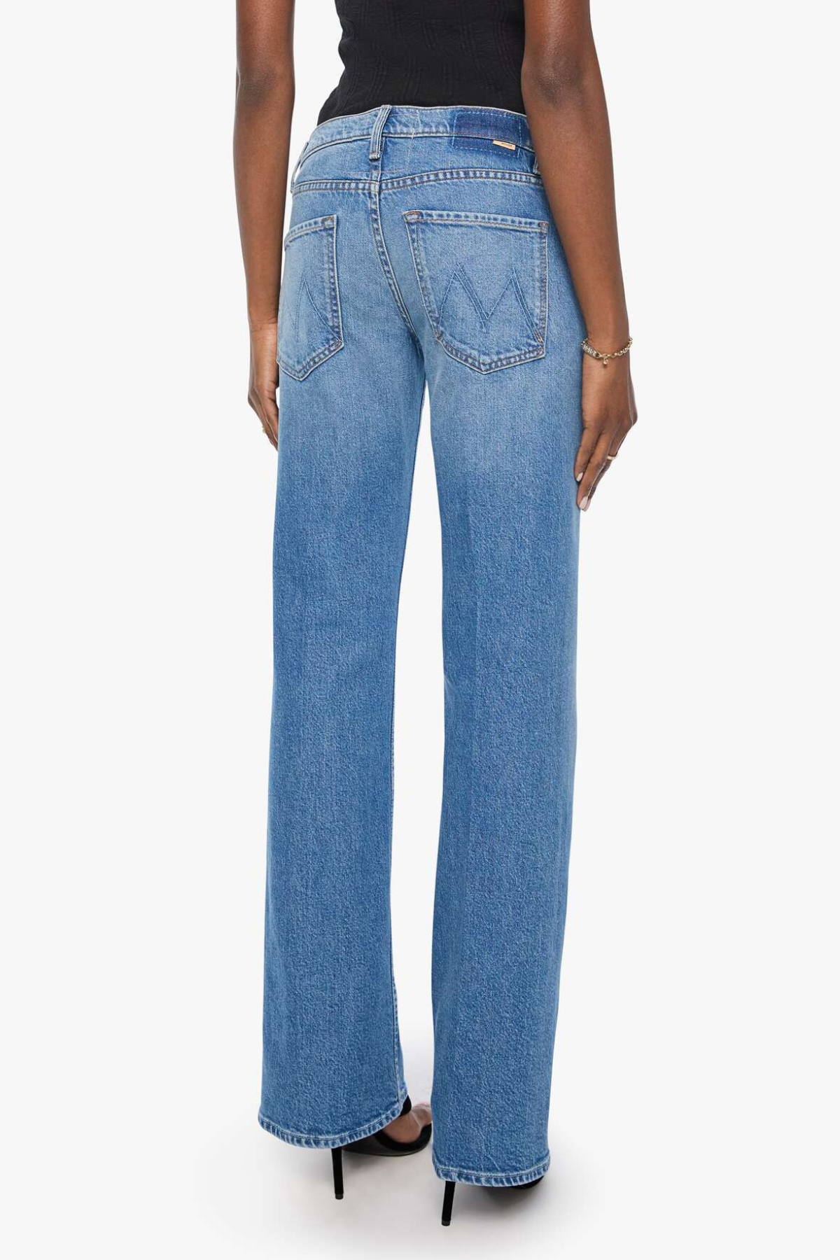 Model wearing light-wash denim jeans with twisted seam detailing and a relaxed straight-leg fit.