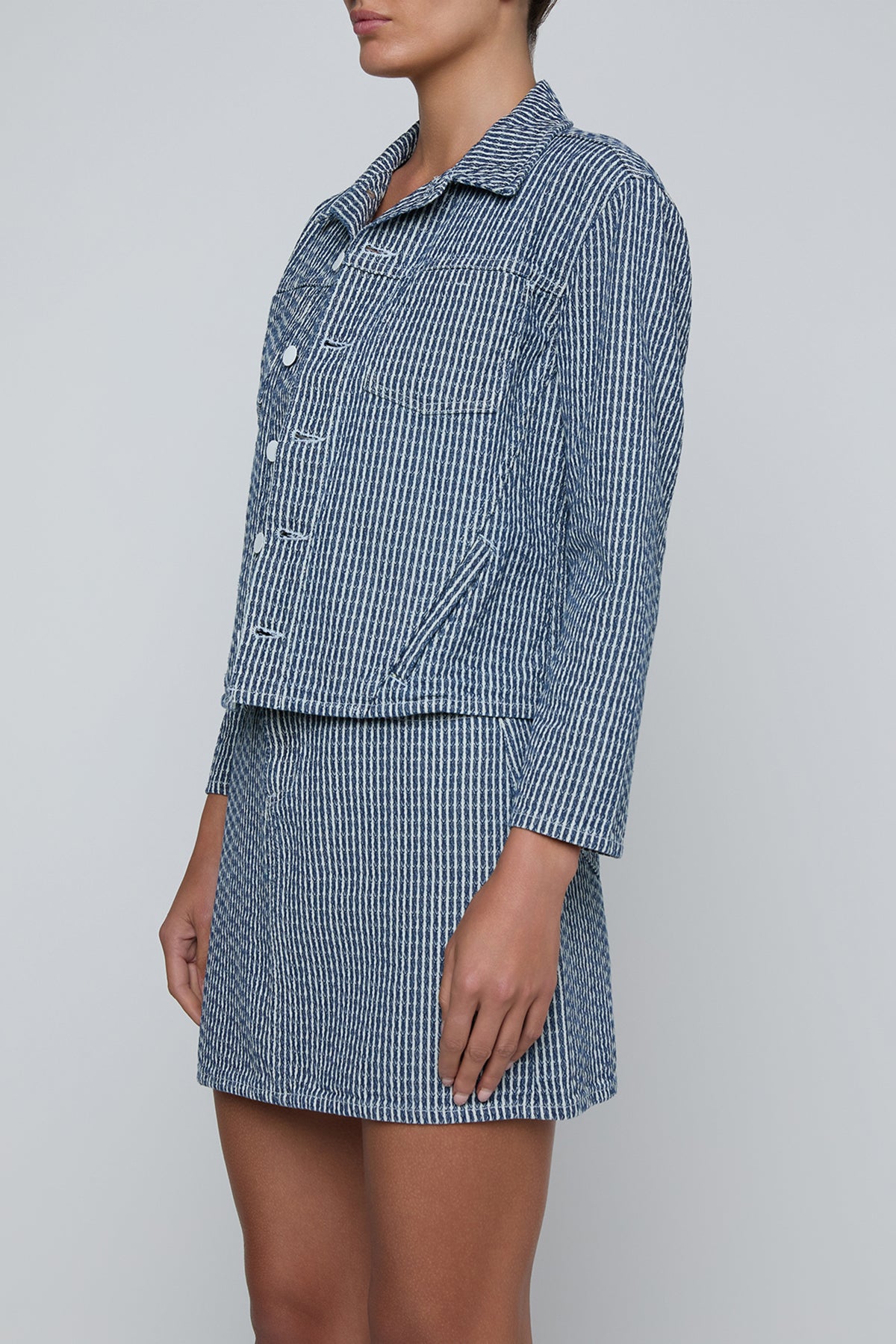 Cropped structured jacket in a muted blue tone.