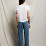 back of woman in white t-shirt and denim 