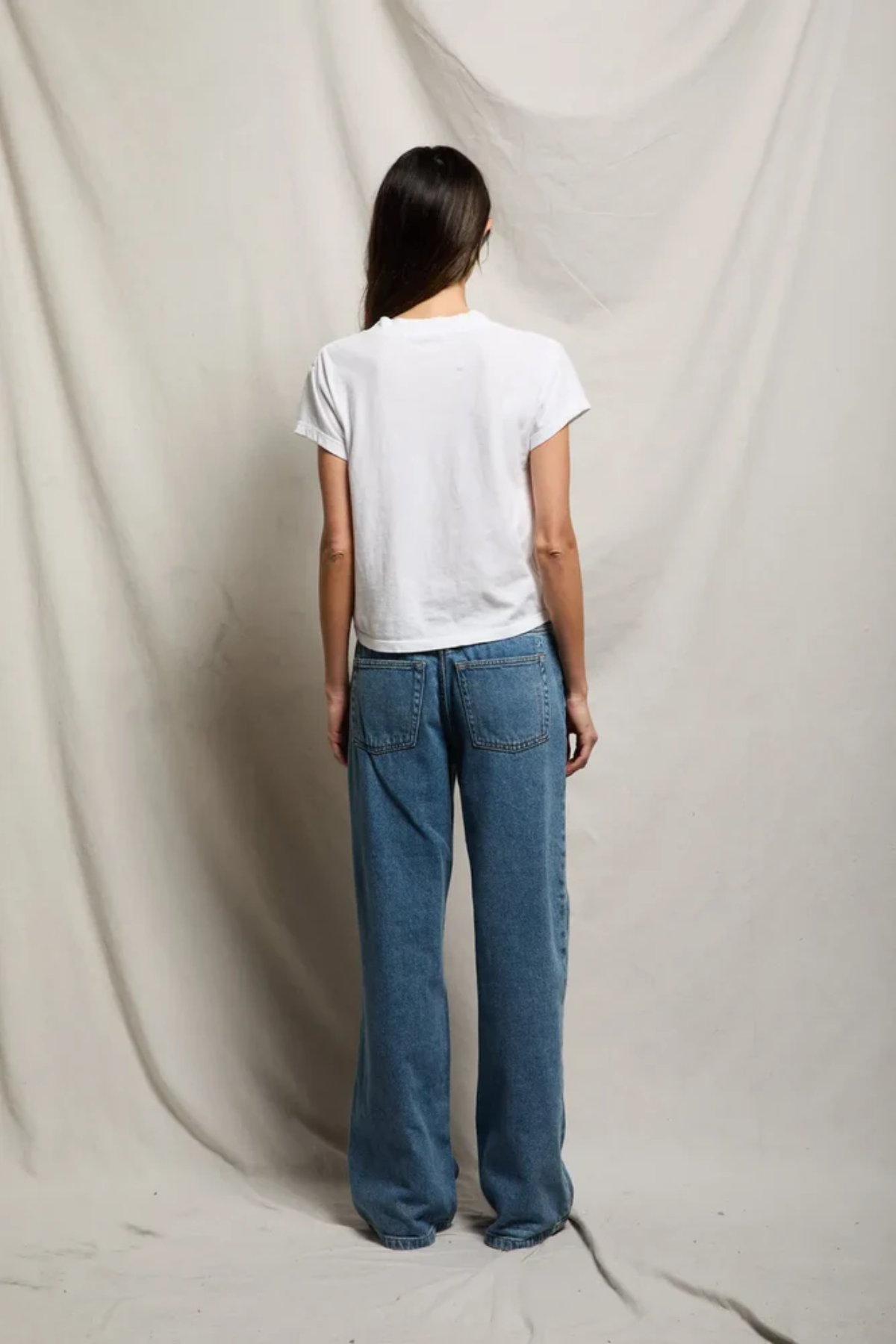 back of woman in white t-shirt and denim 