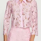 Woman wearing a pink floral outfit on a white background