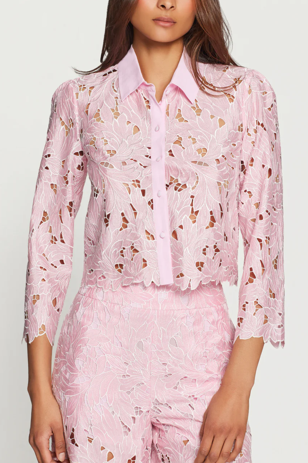 Woman wearing a pink floral outfit on a white background