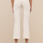 Person wearing white pants with a brown belt on a beige background