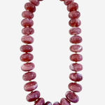 A chunky beaded necklace made of polished oval beads in a dusty rose pink color, separated by small gold spacer beads and finished with a gold clasp, shown on a light gray background.