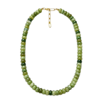A beaded necklace made of round green stone beads in varying shades, with a small gold clasp, shown on a plain white background.