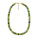 A beaded necklace made of round green stone beads in varying shades, with a small gold clasp, shown on a plain white background.