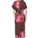 back of woman in floral printed dress on white background 