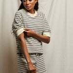 Woman wearing a striped outfit against a plain background