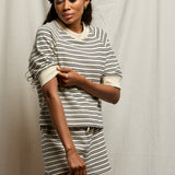 Woman wearing a striped outfit against a plain background