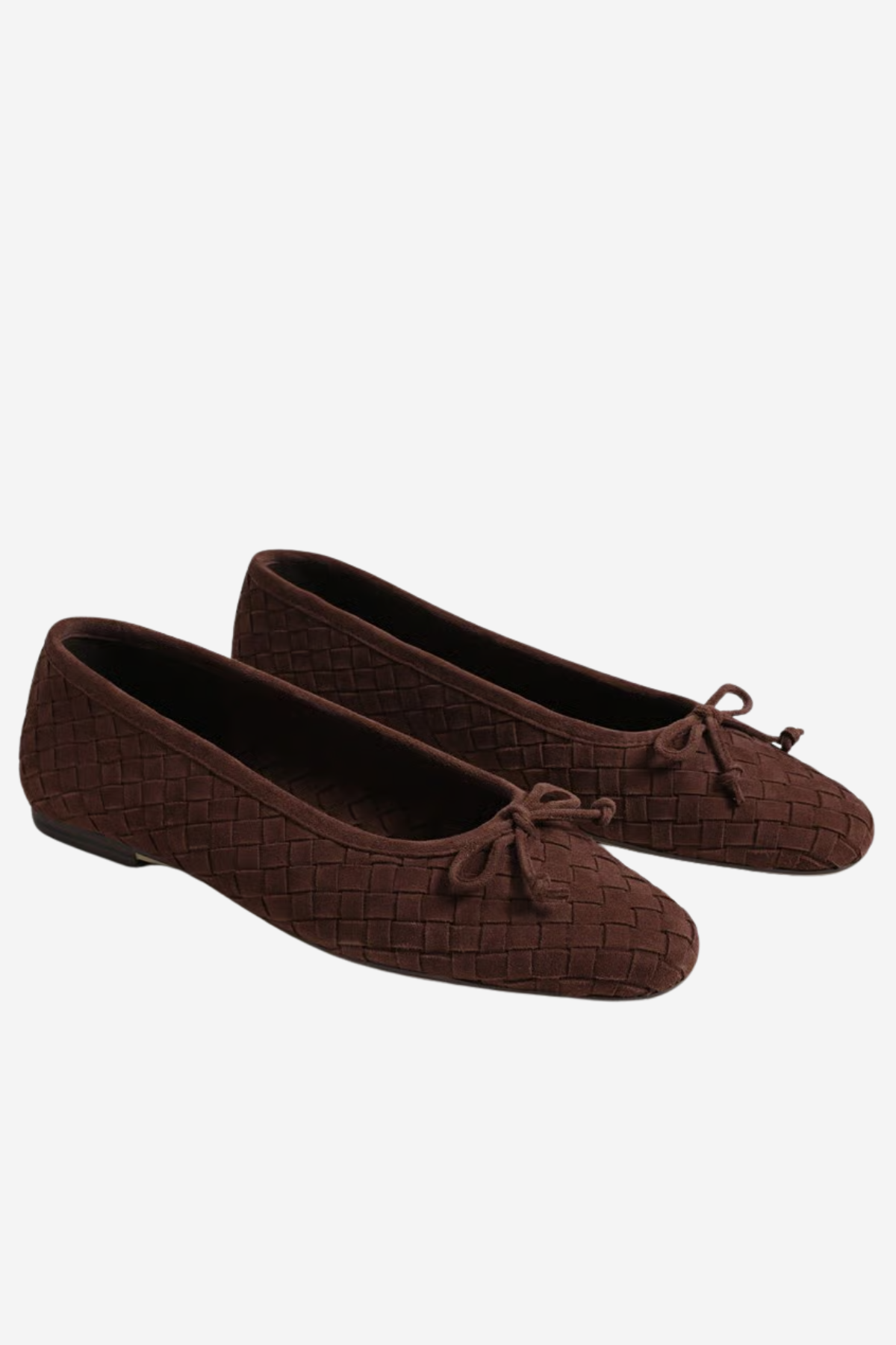 A pair of dark brown woven ballet flats with small bow details on the toes, displayed against a light gray background.