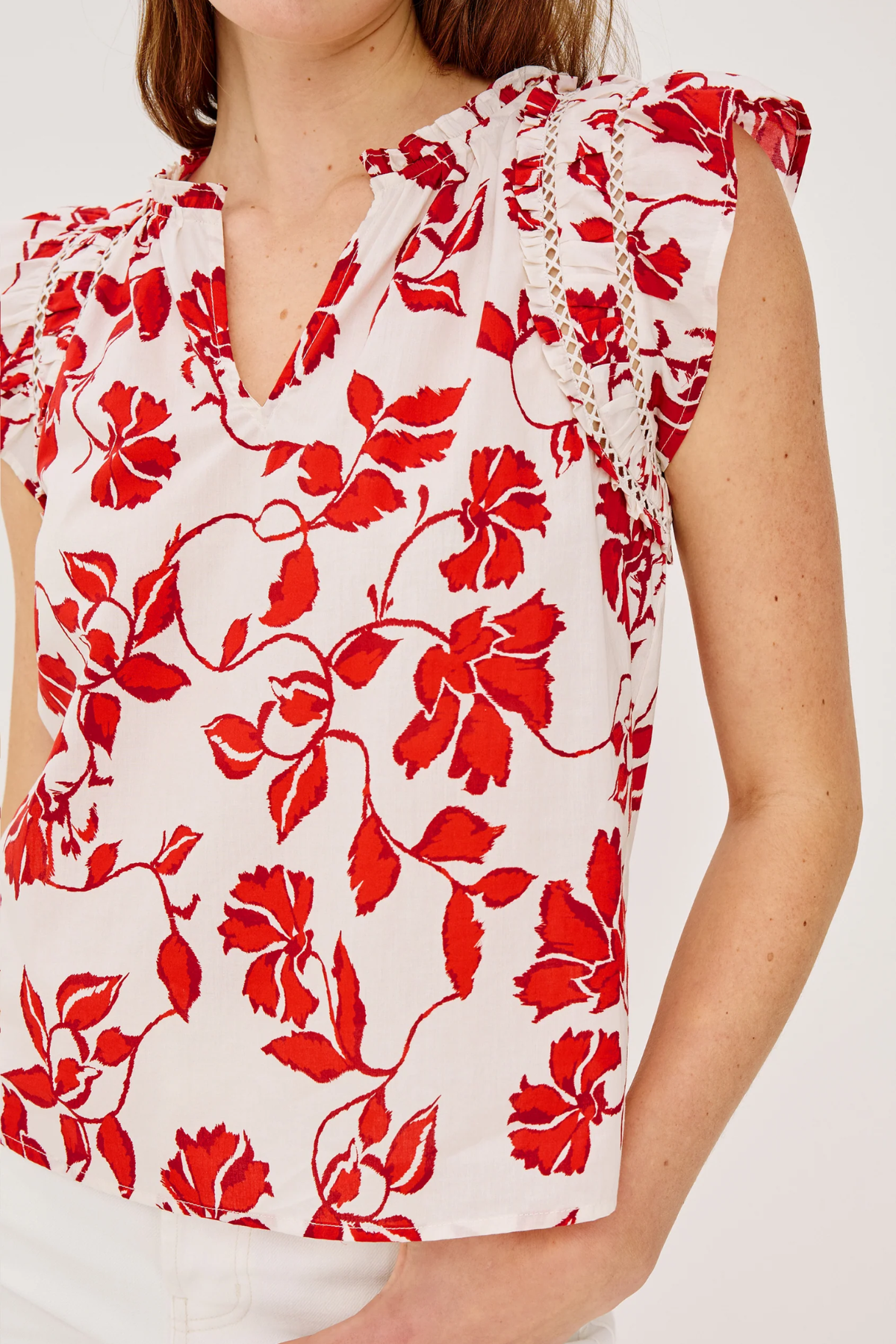 close up of woman in red and white printed blouse on white background 