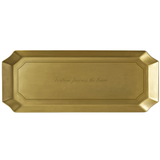 A rectangular gold-toned metal tray with beveled corners and a subtle embossed script in the center, shown against a plain white background.