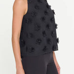 Black sleeveless top with floral embellishments on a white background