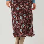 A model wearing a dark brown floral midi skirt with blue, pink, and red flowers, styled with a blue knit sweater and beige knee-high boots against a white studio background.