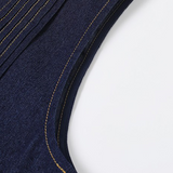 Close-up of a navy blue garment with gold stitching on a white background