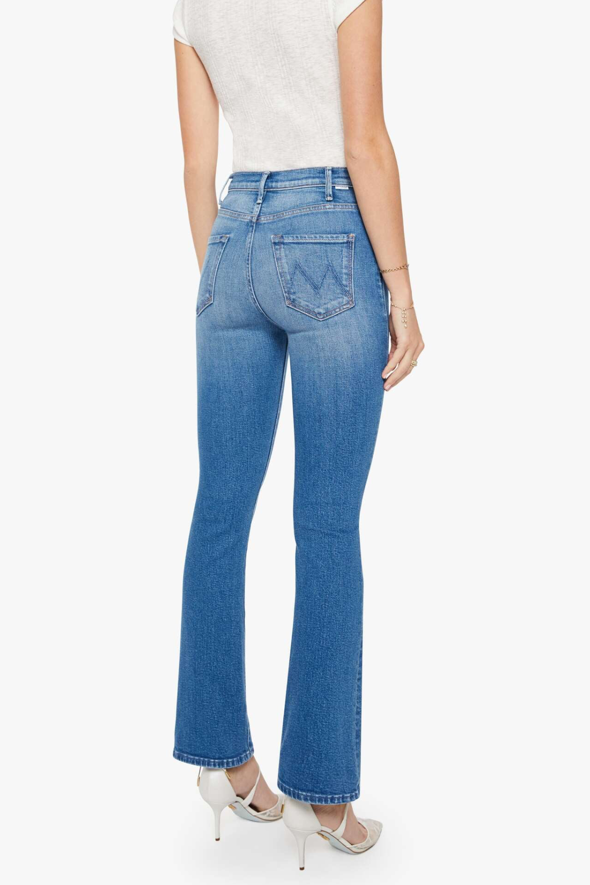 back of woman in blue denim and white tank top on white background 