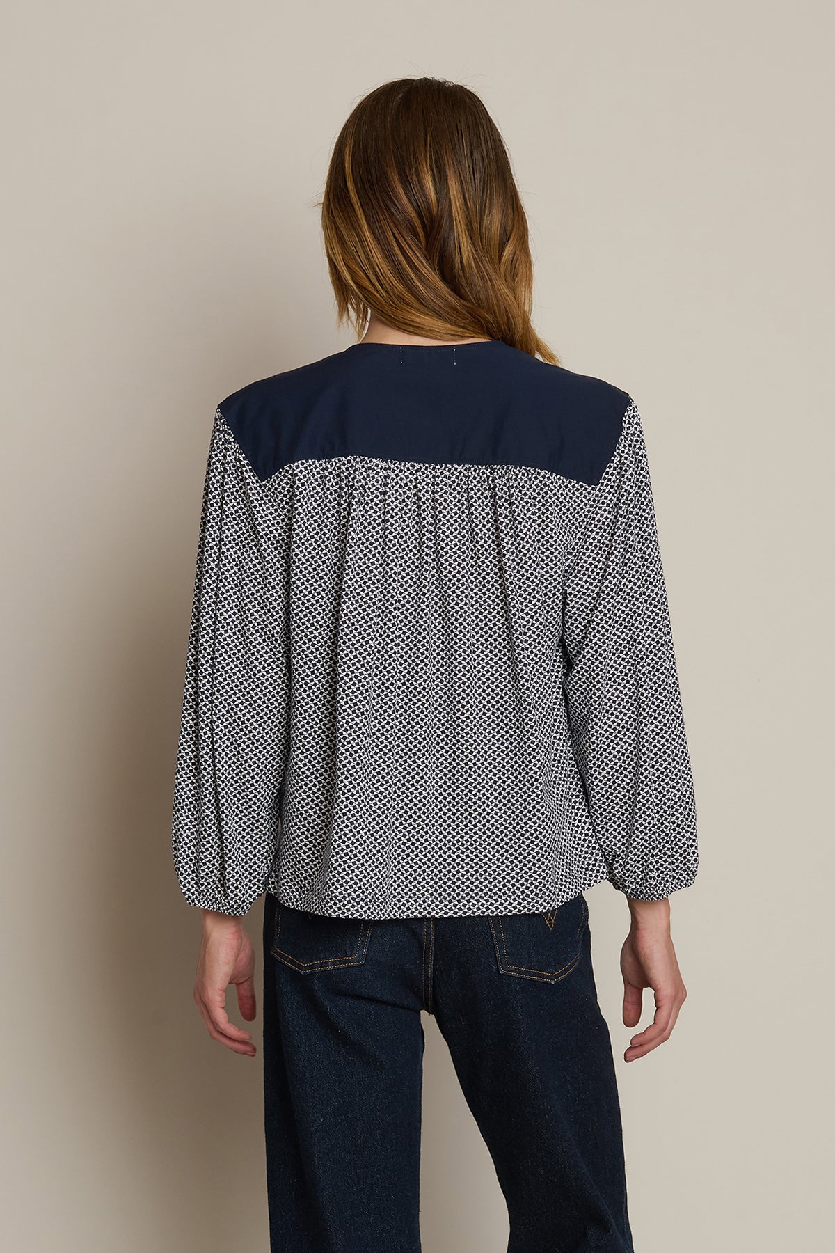 Neutral long-sleeve top styled casually with denim