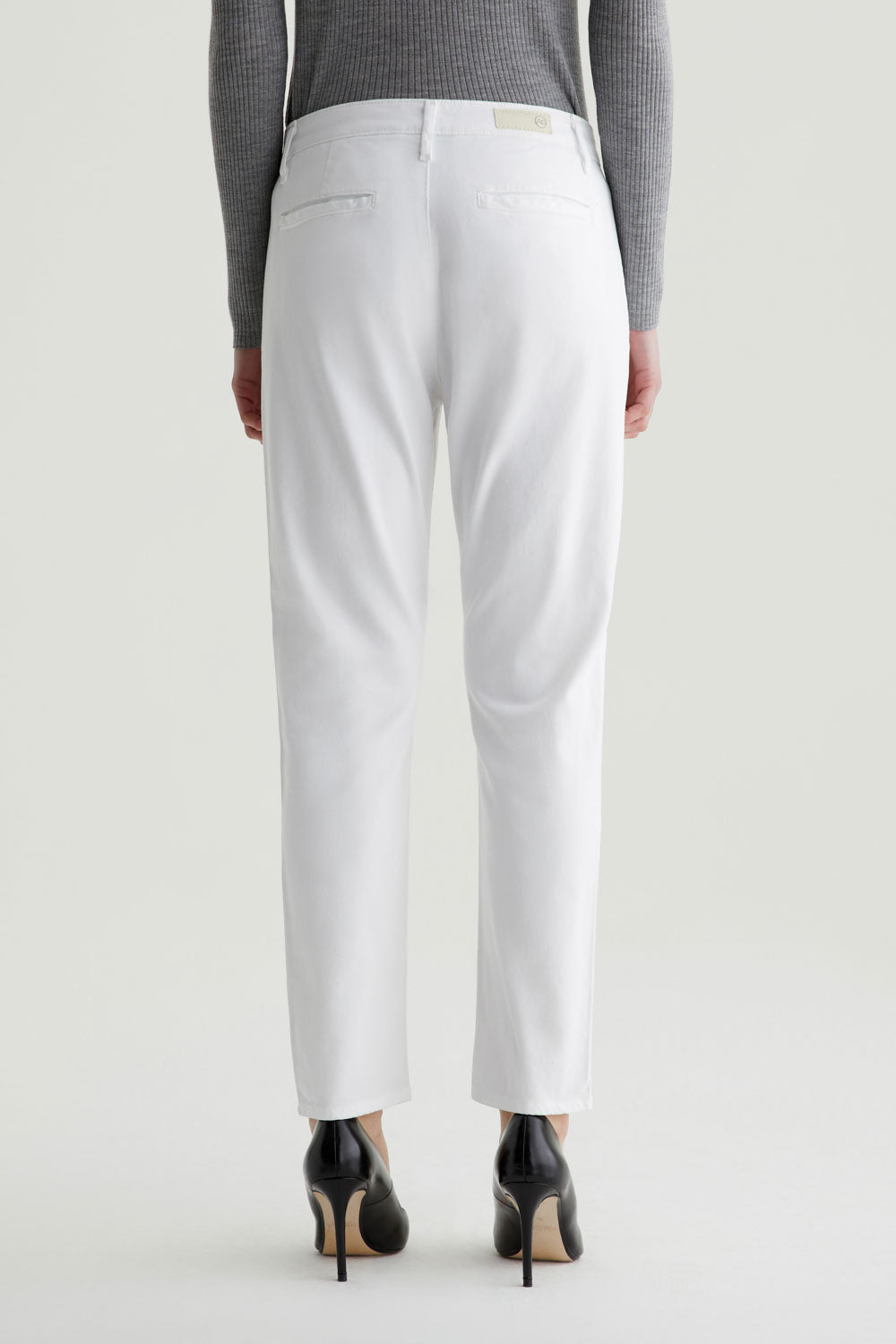 White pants worn by a person on a light gray background