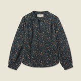 A long-sleeve blouse with a dark navy blue base and a dense orange and yellow floral print, laid flat against a light beige background.