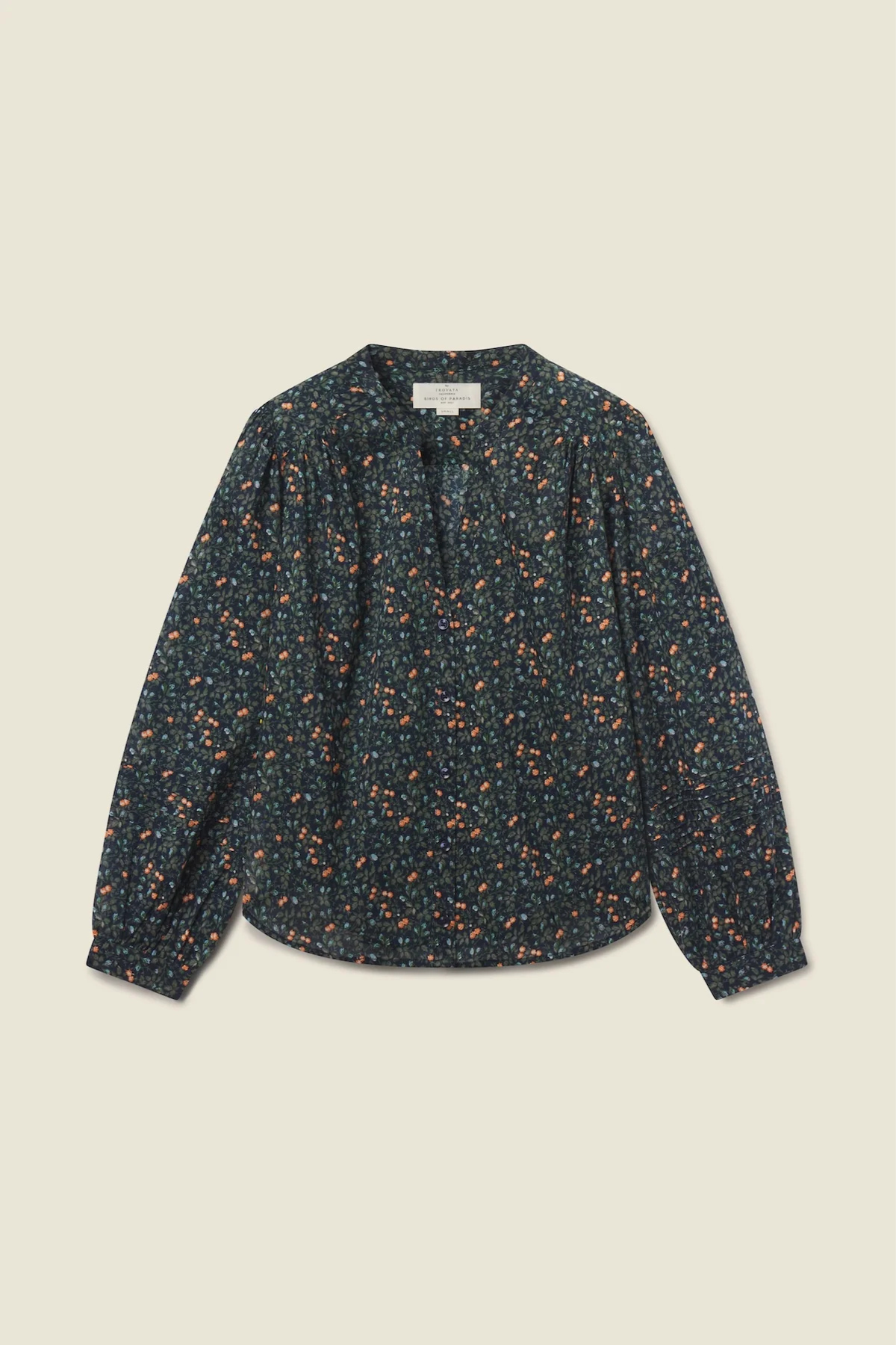 A long-sleeve blouse with a dark navy blue base and a dense orange and yellow floral print, laid flat against a light beige background.