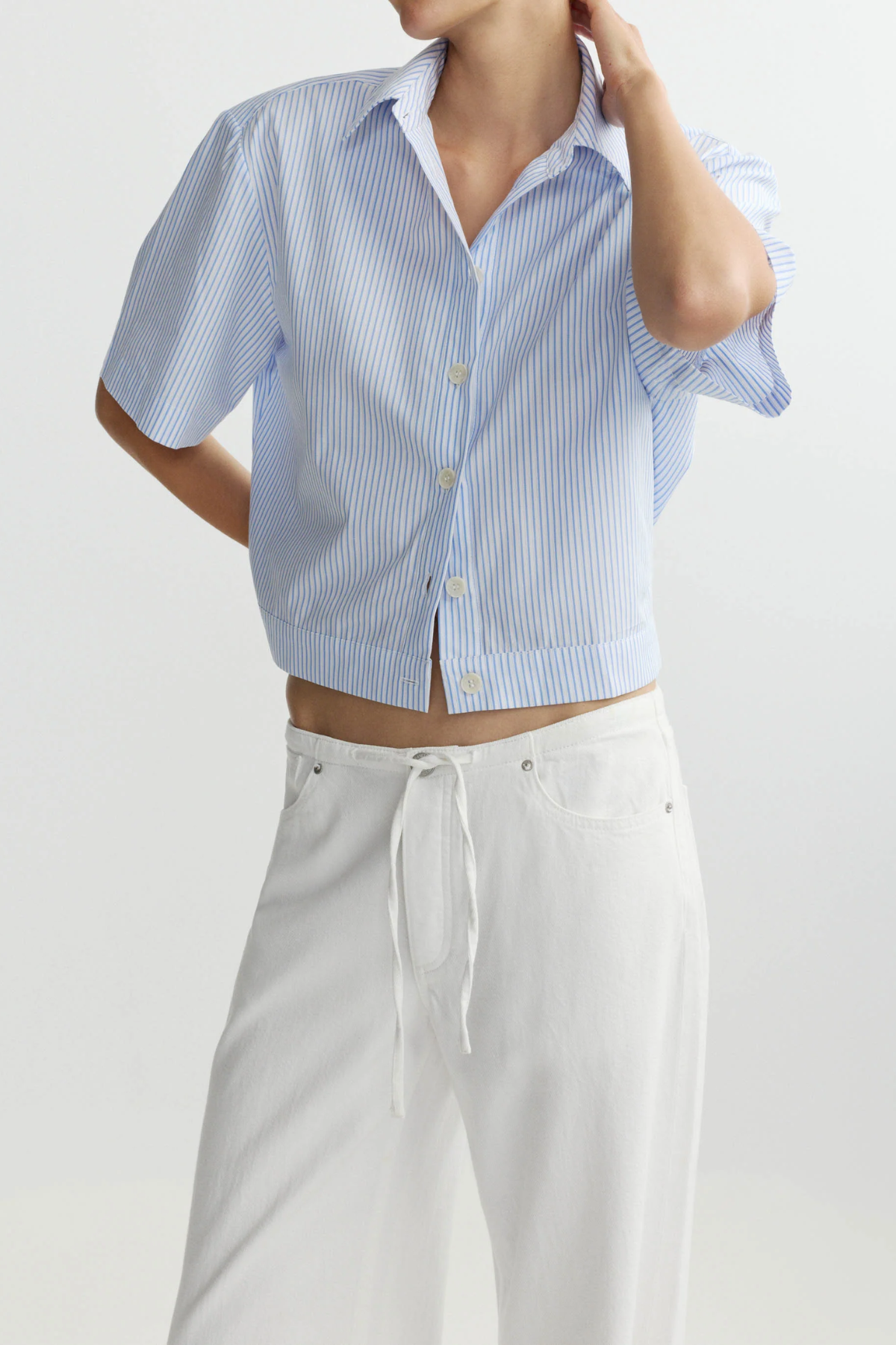 blue striped button up top worn by model against a white background