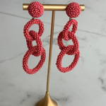 \coral pink linked drop earrings featuring three open circular shapes in a lightweight statement design.