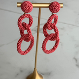 \coral pink linked drop earrings featuring three open circular shapes in a lightweight statement design.
