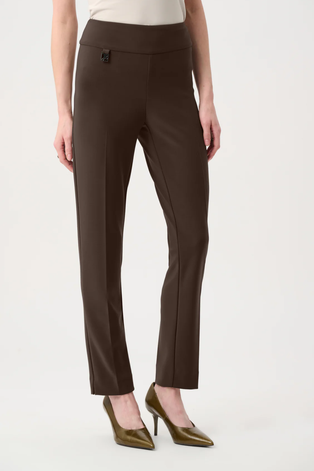 Model wearing slim-fit tailored pants with a streamlined ankle-length silhouette in a classic solid color.