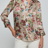 Woman wearing a floral blouse with a plain background